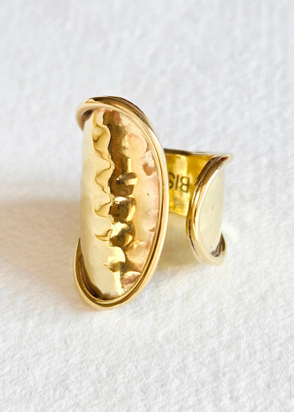 Gold ring with a textured design on a white background