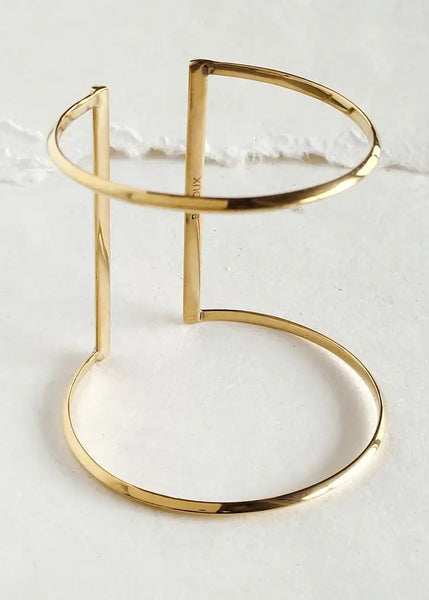 Gold bracelet on a light gray background
