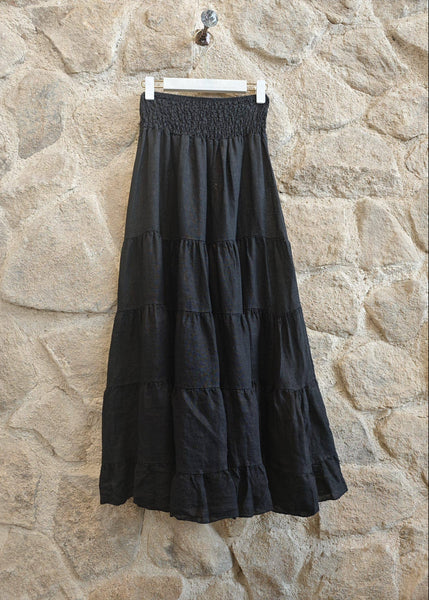 Black tiered skirt hanging against a stone wall