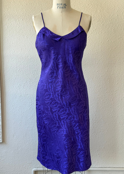 Blue patterned dress on a mannequin against a white wall