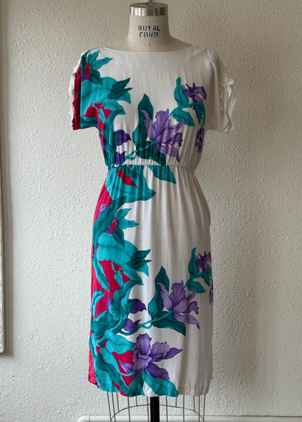 Colorful floral dress on a mannequin against a plain wall