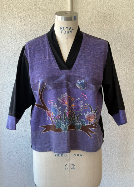 Purple floral embroidered top on a mannequin against a plain background