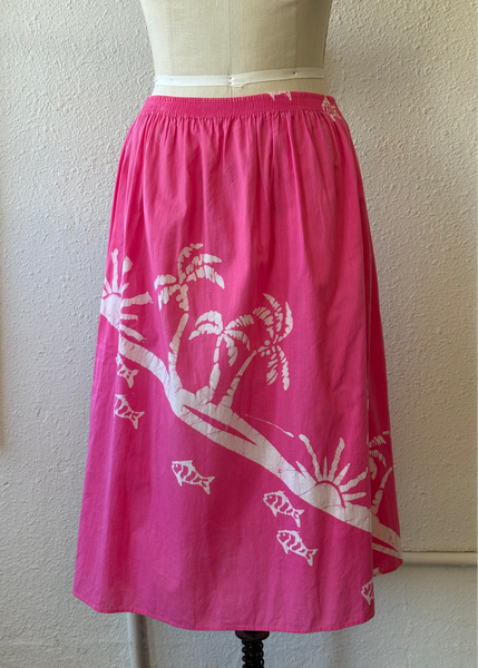 Pink skirt with white tree design on a mannequin against a beige wall.