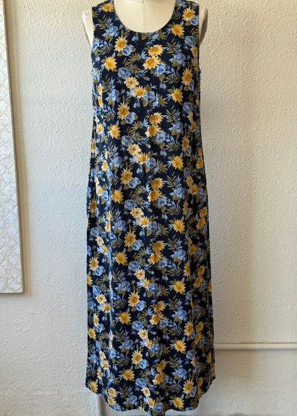 Floral dress with yellow and blue flowers on a mannequin against a white wall.