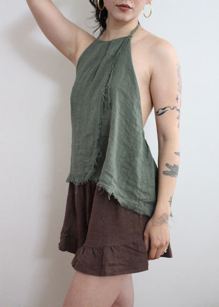 Woman wearing a green and brown layered dress against a white background