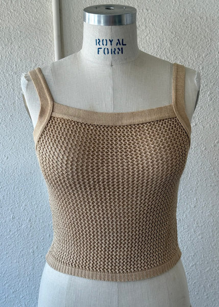 A beige open-knit cropped tank top displayed on a cream mannequin torso against a light textured wall. The mannequin neck is labeled 'ROYAL FERN'.