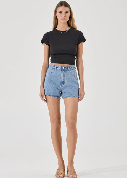 Woman wearing a black t-shirt and denim shorts on a white background