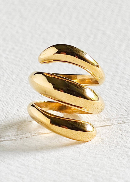 Gold spiral ring on a textured white surface
