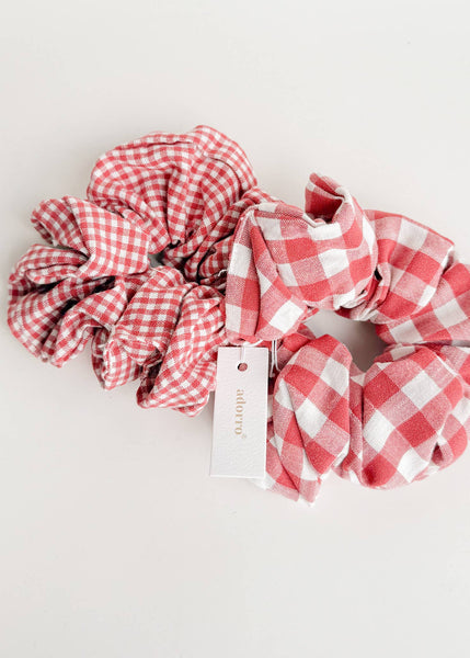 Two red and white checkered scrunchies on a light gray background